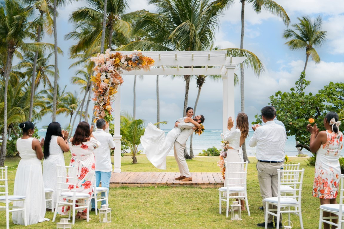 groom lifting new bride into air at destination wedding location
