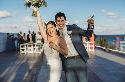 Happy destination wedding couple celebrating by the ocean