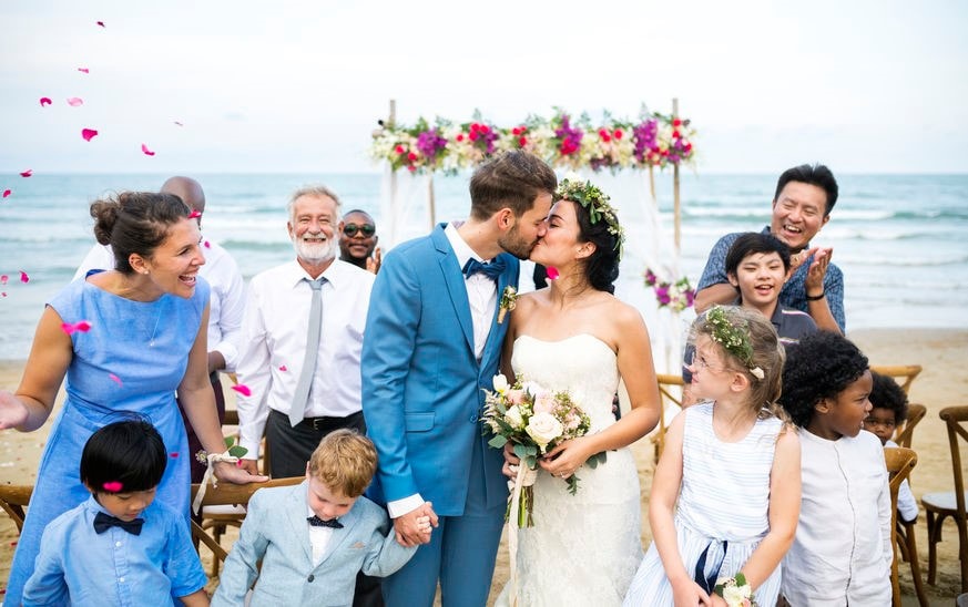 Wedding couple celebrating with family on a beach